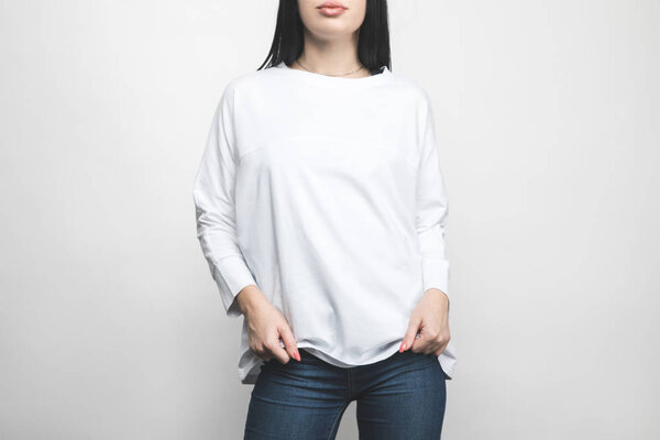 cropped shot of young woman in blank sweatshirt on white