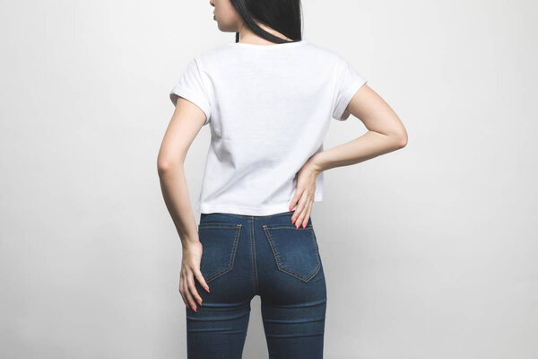 back view of attractive young woman in blank t-shirt on white