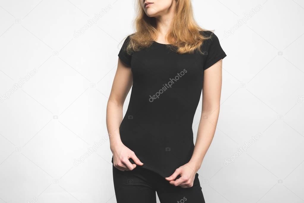 cropped shot of young woman in blank black t-shirt on white