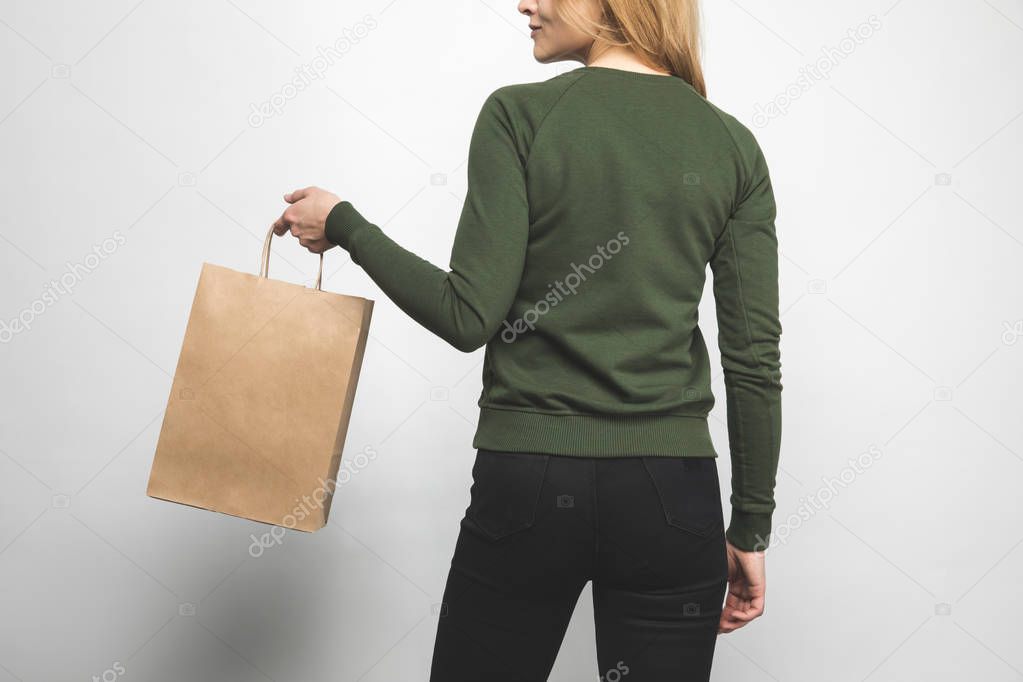 back view of young woman in blank green sweatshirt on white with shopping bag