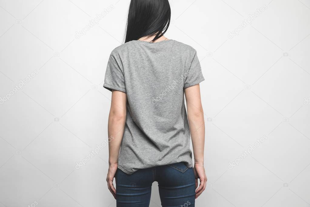 Rear view of young woman in blank grey t-shirt on white