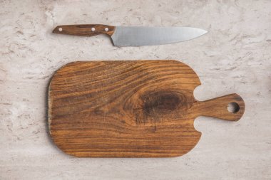 top view of empty cutting board and knife on marble table clipart
