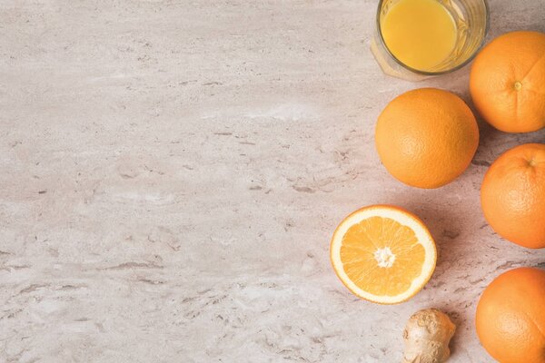 top view of oranges and orange juice on marble table