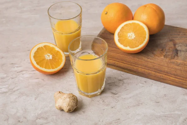 大理石のテーブルに自家製オレンジ ジュースと生姜とオレンジのハイアングル — ストック写真