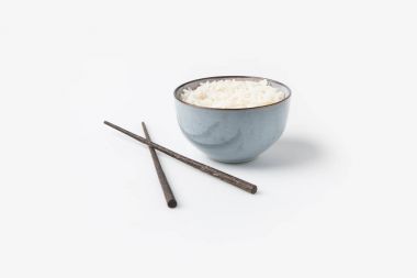 bowl of rice with chopsticks on white tabletop clipart