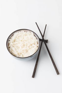 bowl of freshly cooked rice with chopsticks on white tabletop clipart