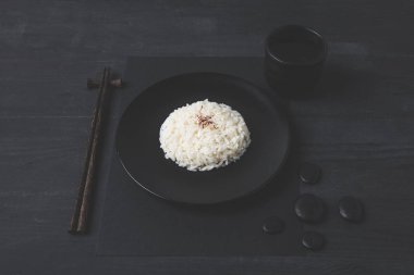 fincan çay ve siyah masada yemek çubukları ile pirinç