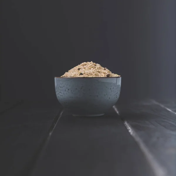 Schüssel Roher Reis Mit Gewürzen Auf Schwarzem Tisch — kostenloses Stockfoto