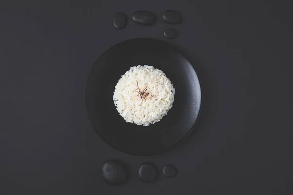Top View Νόστιμο Ρύζι Στο Πιάτο Βότσαλα Στον Μαύρο Πίνακα — Φωτογραφία Αρχείου