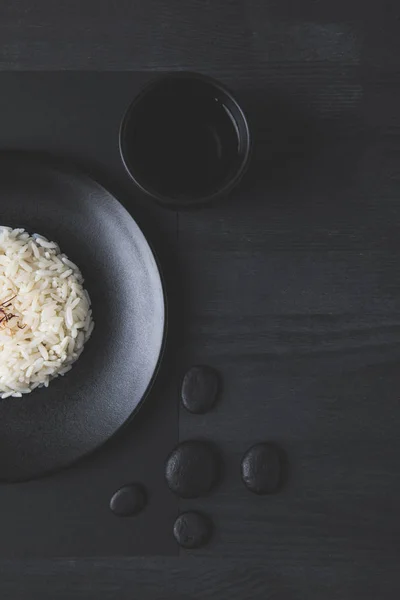 Κάτοψη Του Ρυζιού Στο Πιάτο Φλυτζάνι Του Τσαγιού Στον Μαύρο — Φωτογραφία Αρχείου
