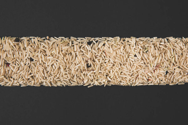 top view of stripe of raw rice isolated on black