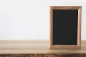 one empty blackboard on wooden table on white 