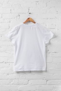 one white shirt on hanger on white wall clipart