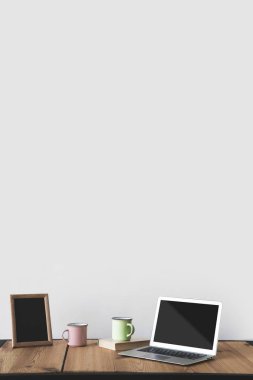 bardak ve laptop beyaz çerçeve içinde boş yazı tahtası 