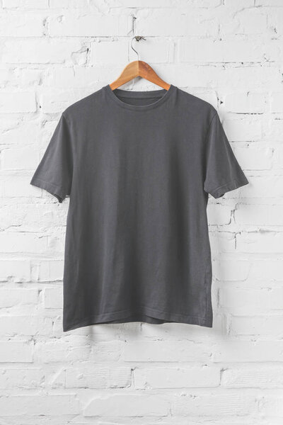 one dark grey shirt on hanger on white wall