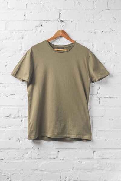 one brown shirt on hanger on white wall