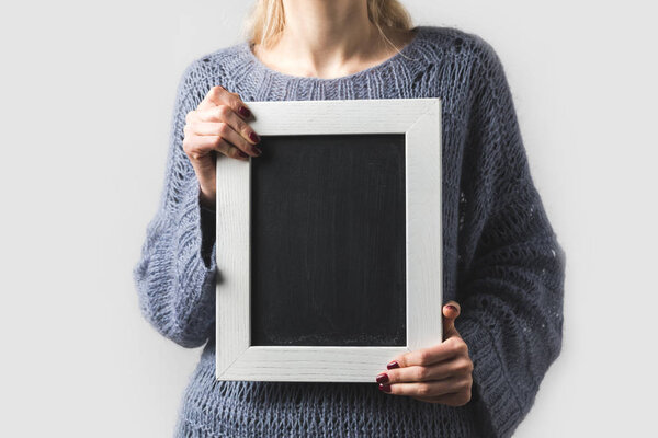 cropped image of woman holding empty black board isolated on white