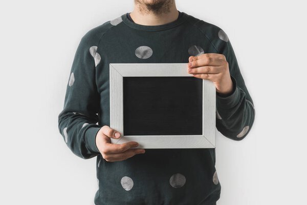 cropped image of man holding empty black board isolated on white