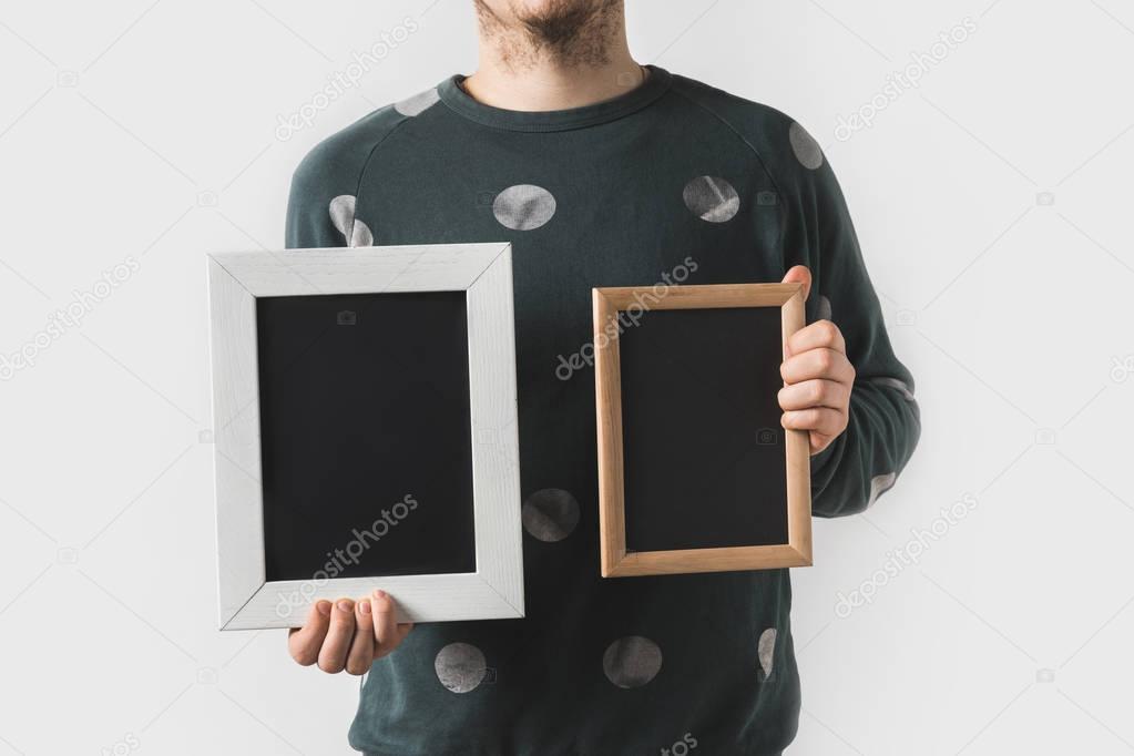 cropped image of man holding empty black boards isolated on white