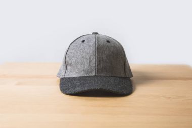 one grey cap on wooden table on white  clipart