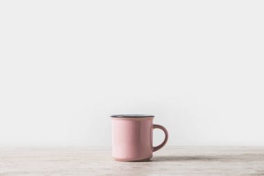 one pink cup on marble table on white