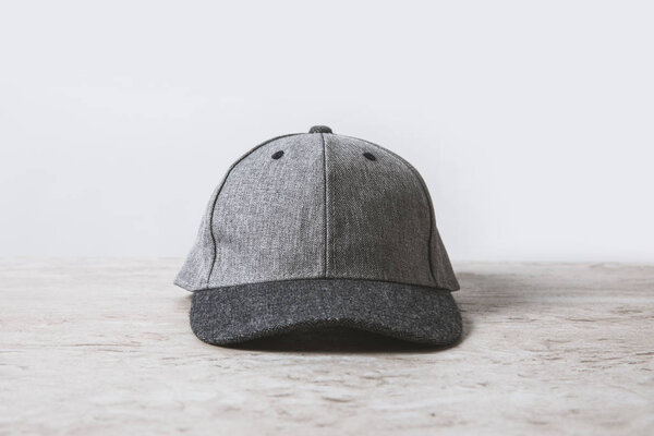 one grey cap on wooden table on white 
