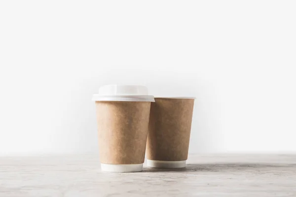 disposable coffee cups on marble table on white