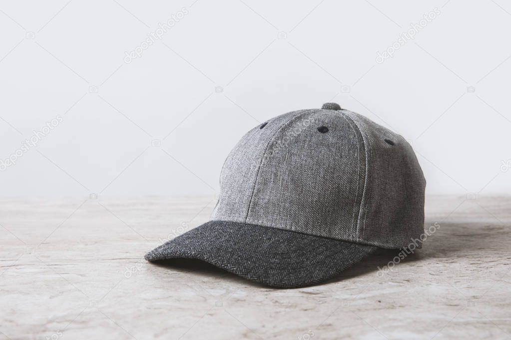 one grey cap on wooden table on white 