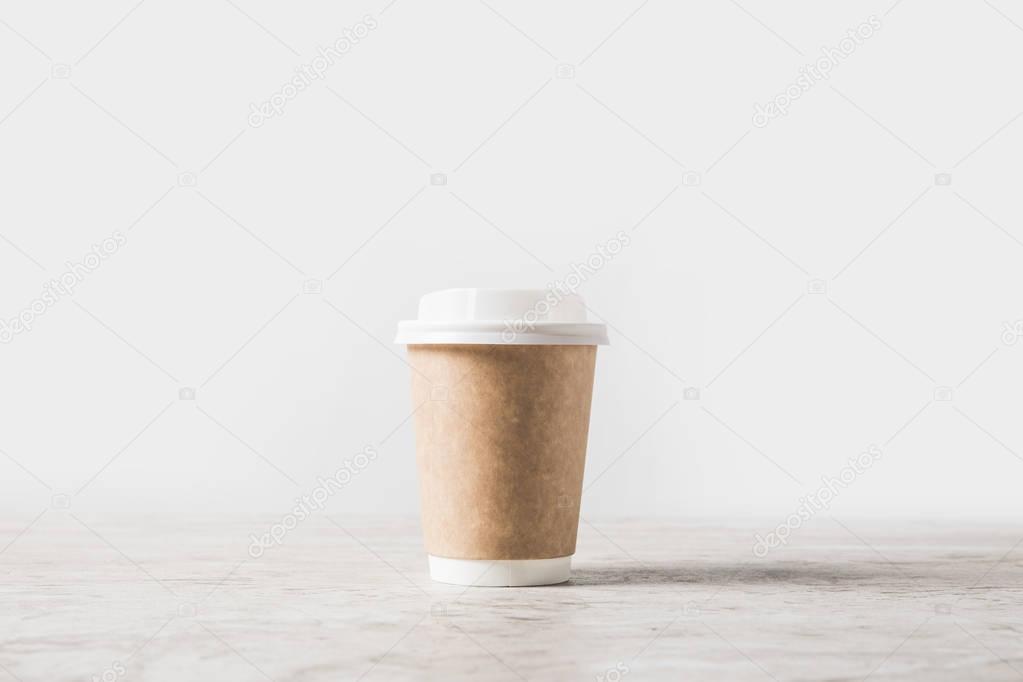 one disposable coffee cup on marble table on white 