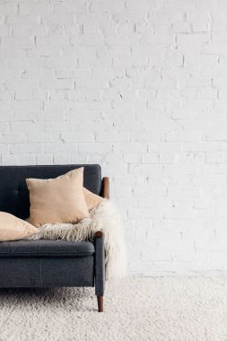 cropped shot of couch with pillows and blanket in living room with white brick wall, mockup concept clipart