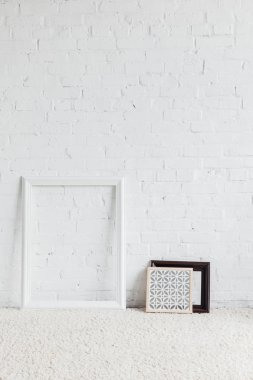 picture frames with leaning on white brick wall, mockup concept clipart