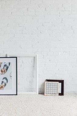 pictures in frames leaning on white brick wall, mockup concept clipart