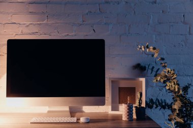 Akşamları, mockup kavramı masa lambası tarafından aydınlatılmış işyeri ekranda boş copmuter