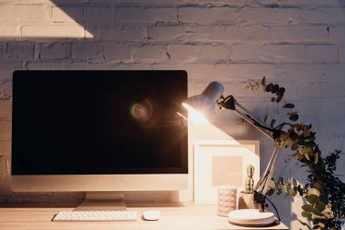 işyeri tarafından masa lambası, mockup kavramı ışıklı ekranda boş copmuter