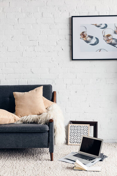 частичный вид на современный интерьер гостиной с удобным диваном и изображение на белой кирпичной стене, макет концепции
