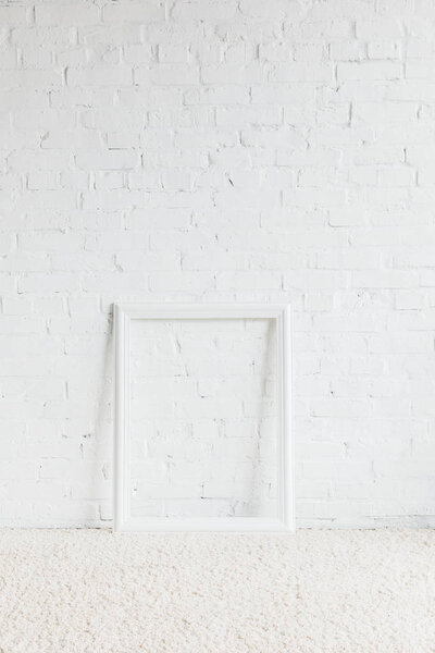 empty frame in front of white brick wall, mockup concept