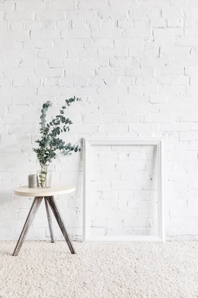 Empty frame in front of white brick wall with flower pot on table, mockup concept — Stock Image Empty Frame Front White Brick Wall Flower Pot Table Mockup Royalty Free Stock Images