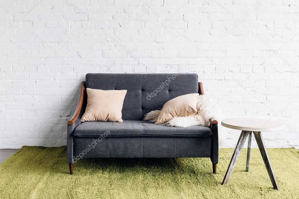 small couch in modern living room with white brick wall, mockup concept