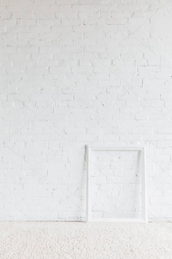 empty frame in front of white brick wall, mockup concept
