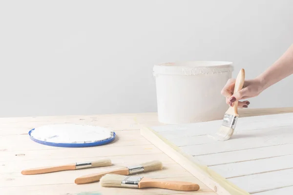 Bijgesneden Afbeelding Van Meisje Schilderen Houten Oppervlak Met Witte Verf — Stockfoto