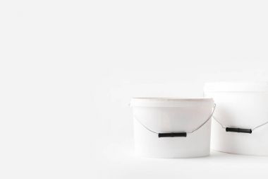 two plastic white buckets with paints isolated on white clipart