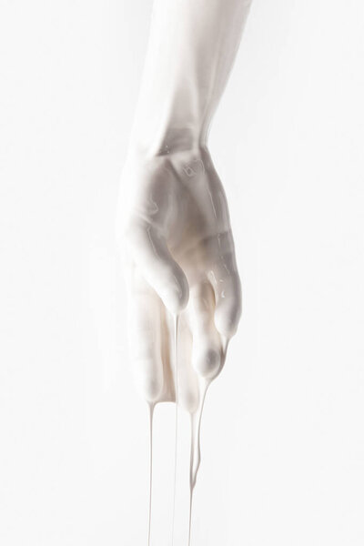cropped image of female hand in white dripping paint isolated on white