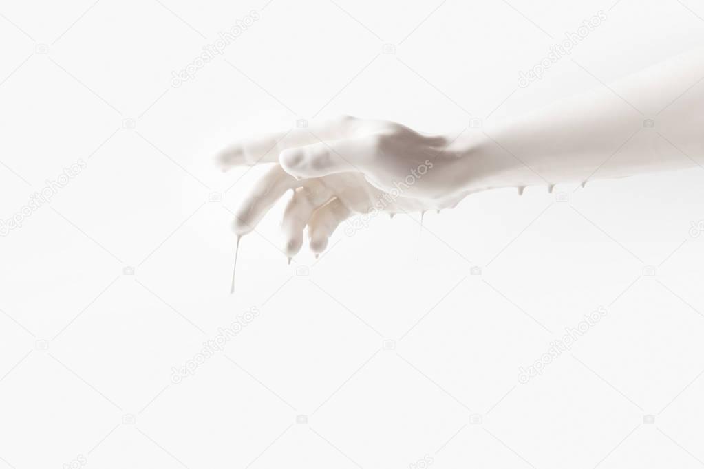 cropped image of female arm in white paint isolated on white