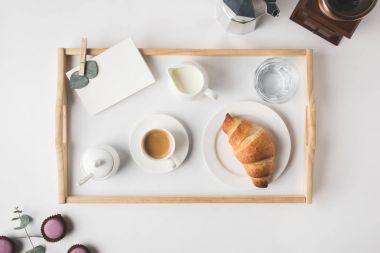 düz lay ile fincan kahve ve kruvasan kahvaltı tepsi üzerinde beyaz masa üstü için