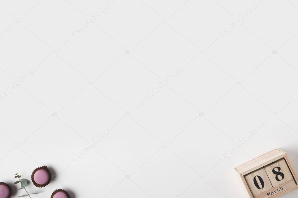 top view of calendar, plant and sweet desserts on white tabletop