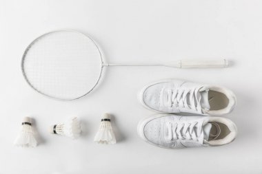 top view of badminton racket with suttercocks in row and sneakers on white surface clipart