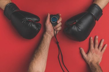 cropped shot of fighter in gloves and his trainer with stopwatch on red tabletop clipart