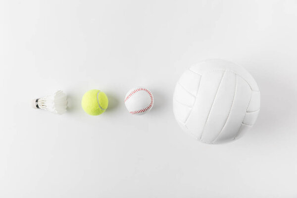 various sports equipment in row on white surface