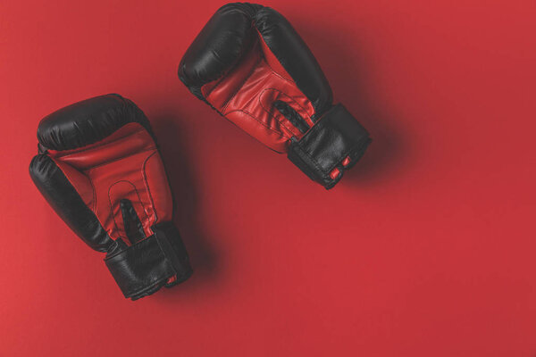 top view of boxing gloves lying on red tabletop