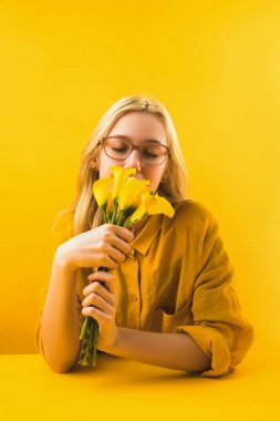 güzel sarı calla lily çiçekler sarı üzerinde tutan kız